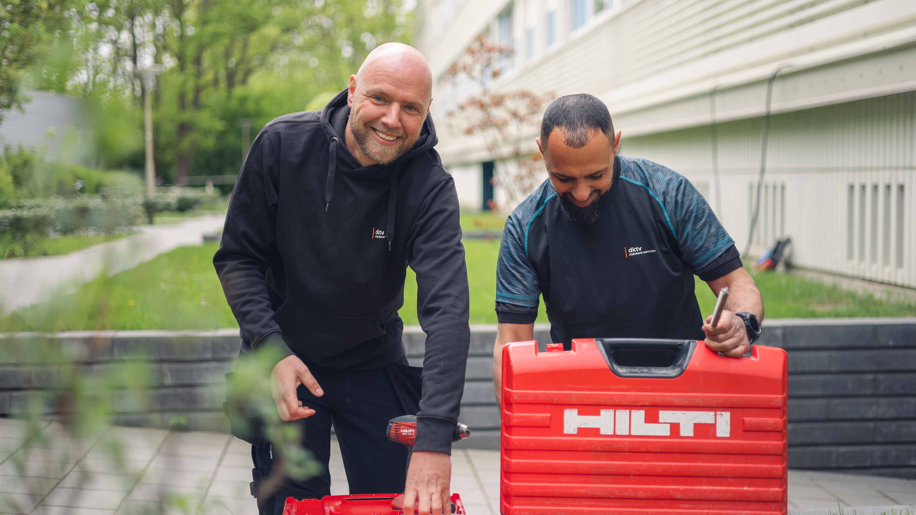 Teknikere Foran Opgang Med Vaerktøj