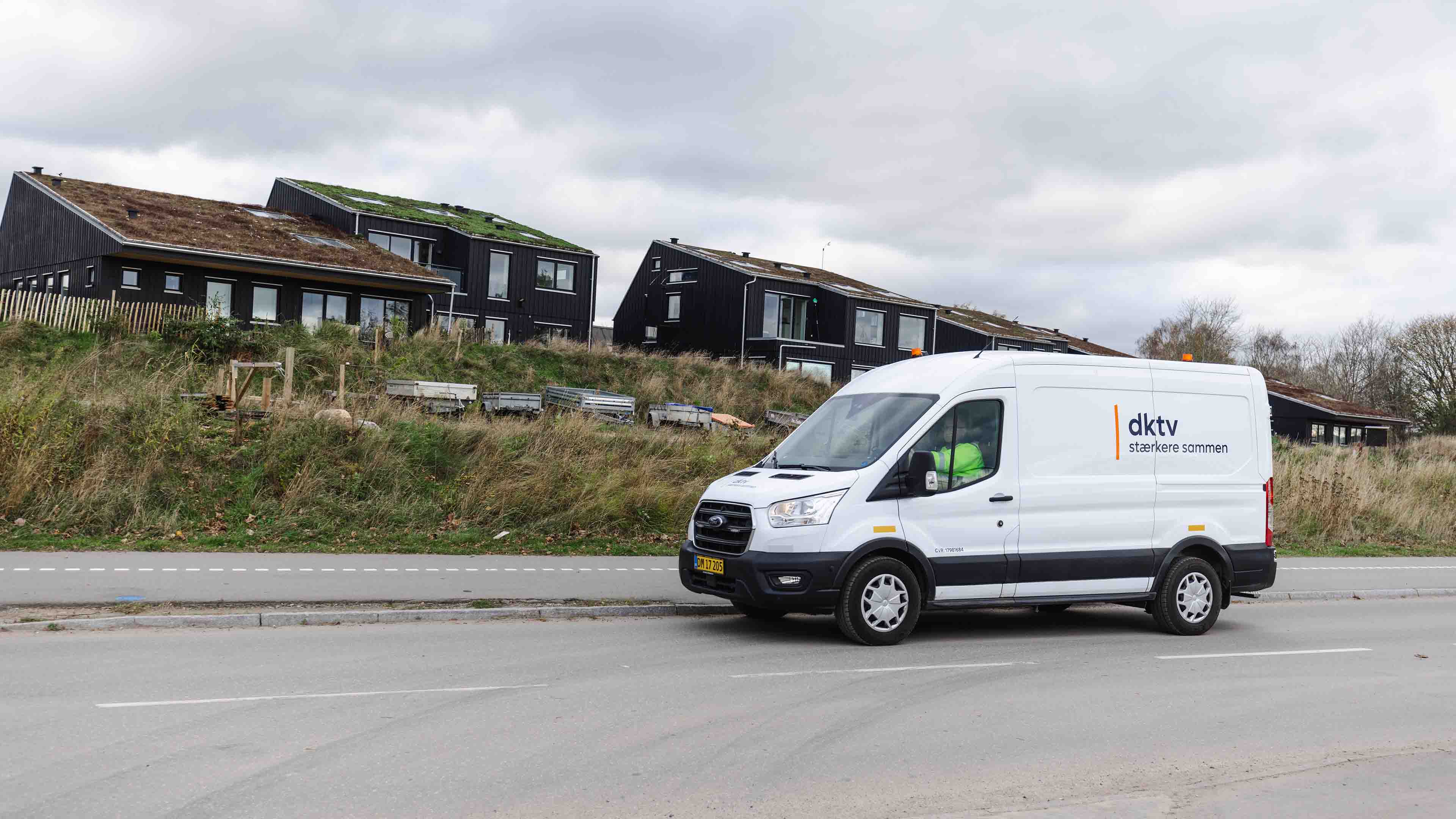 Teknikerbil Foran Huse Med Græs På Taget